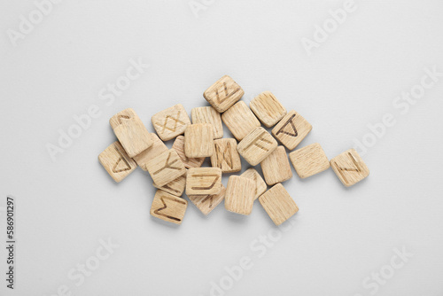 Pile of wooden runes on white background, flat lay