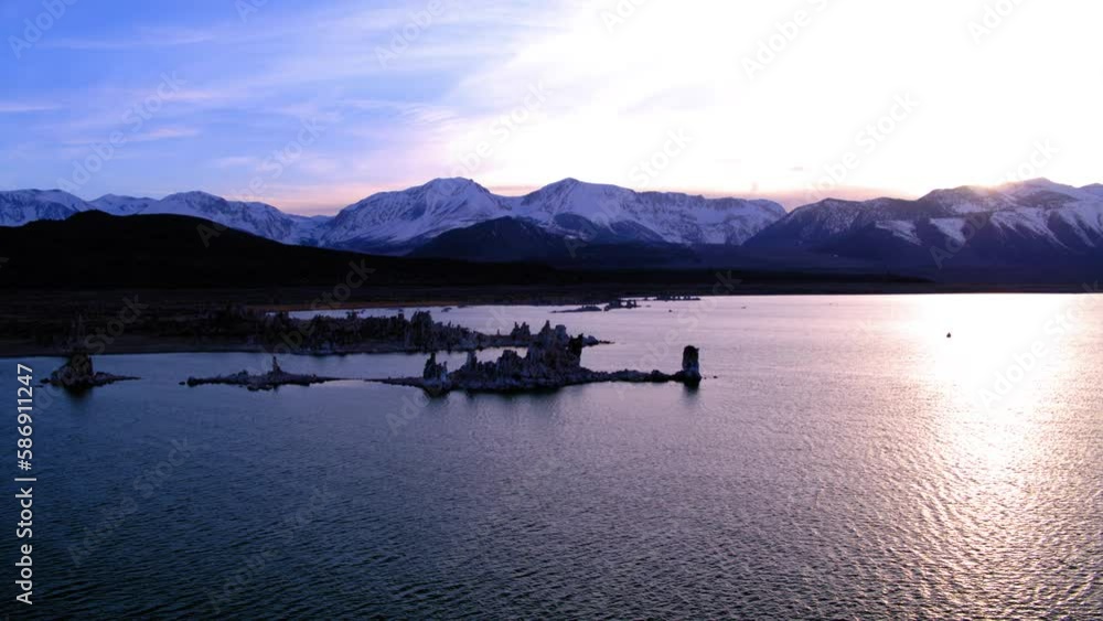 Aerial Panning Shot Of Idyllic Mono Lake By Snowy Mountains Under Sky During Sunset - Sierra County, California Aerial Panning Shot Of Idyllic Mono Lake By Snowy Mountains Under Sky During Sunset - Sierra County, California