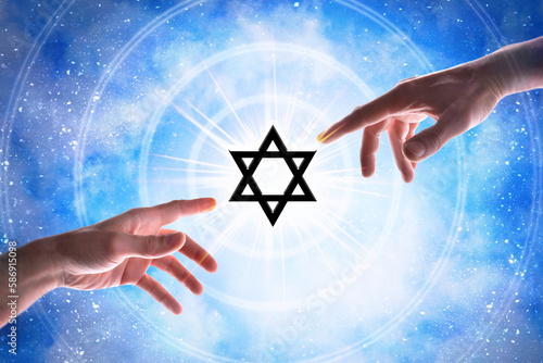 Hands pointing jew symbol with blue universe background photo
