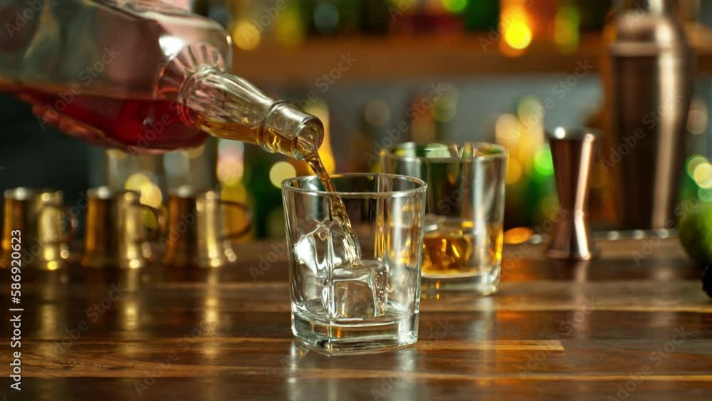 Detail of whisky bottle, pouring shot into glass, super slow motion. Filmed on high speed cinema camera, 1000fps. Detail of whisky bottle, pouring shot into glass, super slow motion. Filmed on high speed cinema camera, 1000fps.