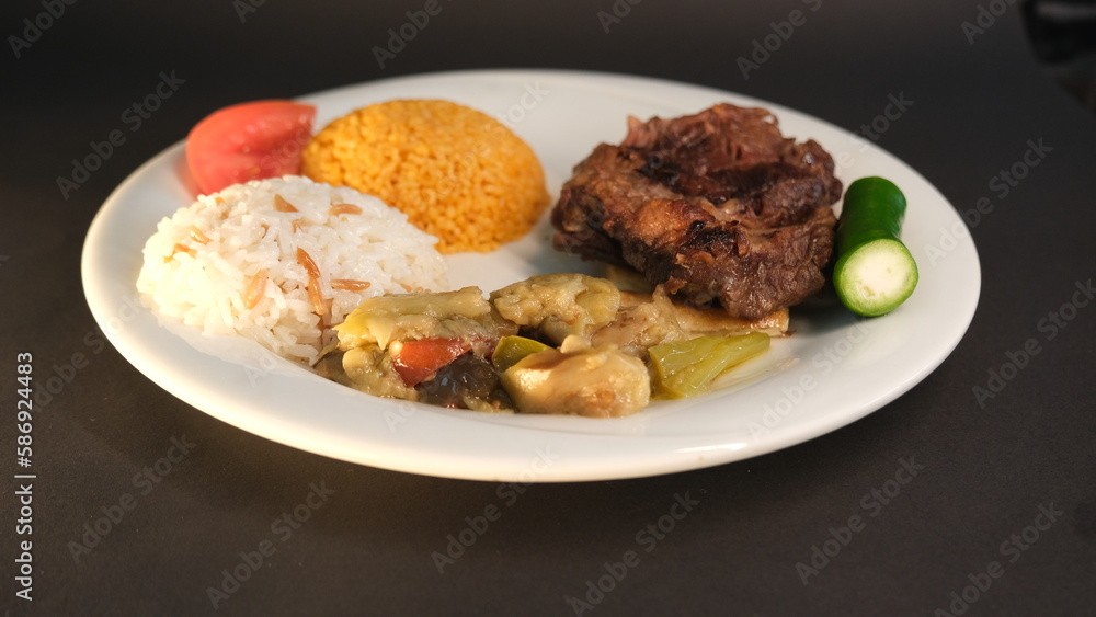 Beef breast ribs served with rice and appetizers on a serving plate