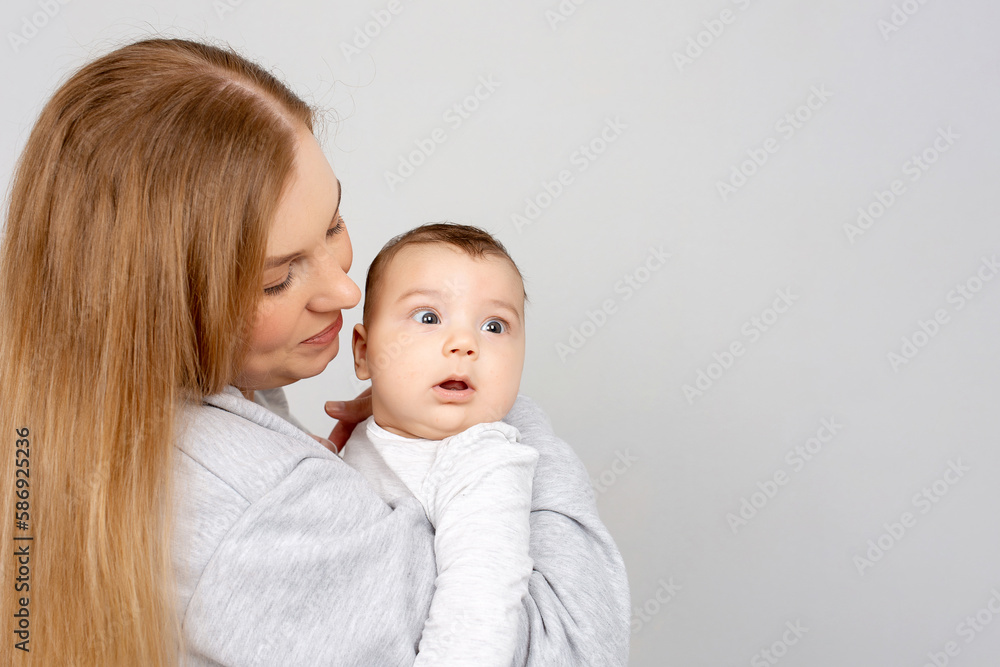 Mom and baby play on the bed. Mother and son, happy family, beautiful blonde girl and cute baby at home. Mom and baby play on the bed. Mother and son, happy family, beautiful blonde girl and cute baby at home.