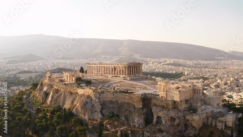 Greece Acropolis city of Athens parthenon symbol of ancient aerial view slide from drone on panorama of residential buildings at sunset summer. Lights sun, lens flare. World Heritage sites. History