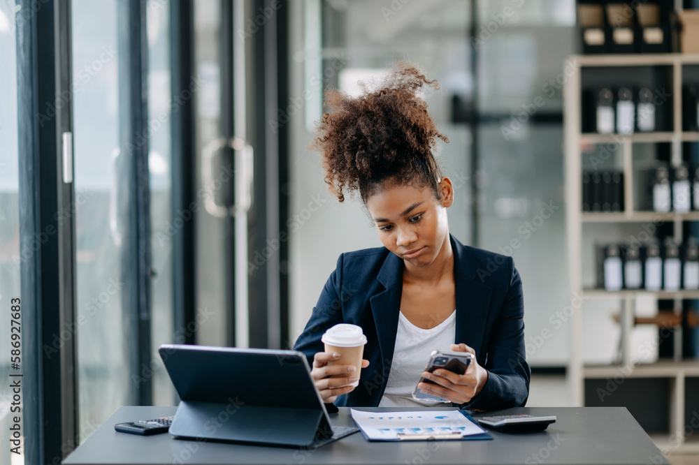 Young attractive African female office worker business suits smiling at camera in office Young attractive African female office worker business suits smiling at camera in office