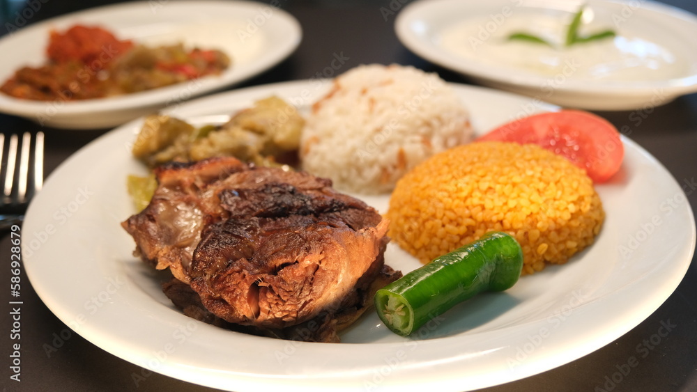 Beef breast ribs served with rice and appetizers on a serving plate Beef breast ribs served with rice and appetizers on a serving plate