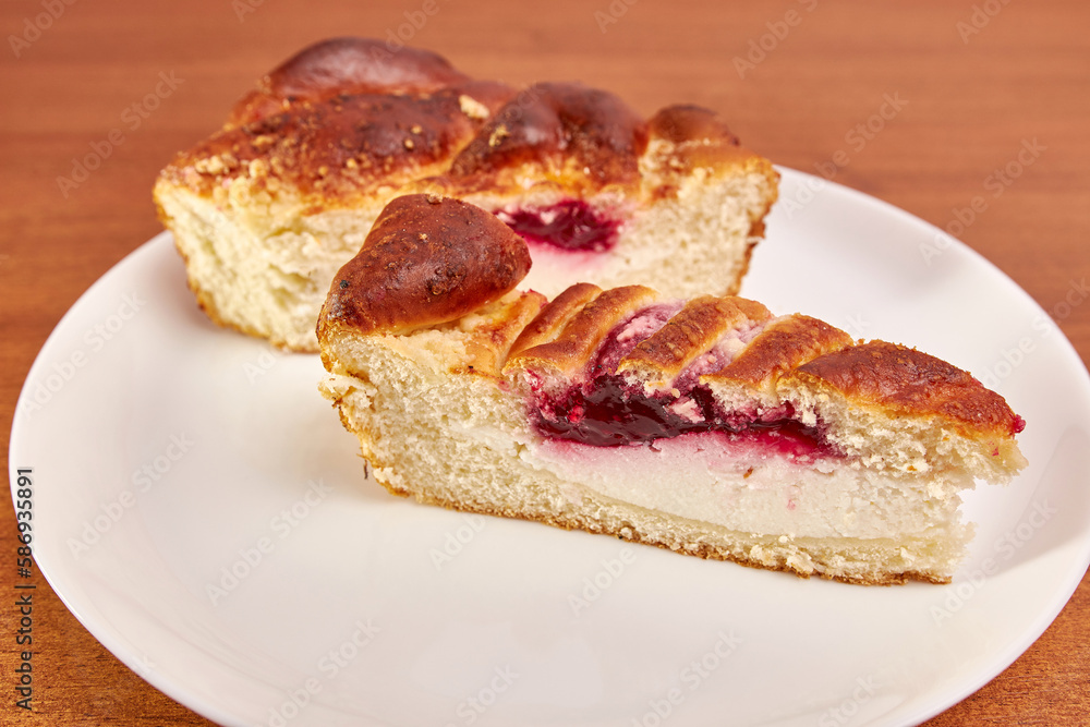 Delicious pie with cheese and cherry jam on a white plate. Delicious pie with cheese and cherry jam on a white plate.