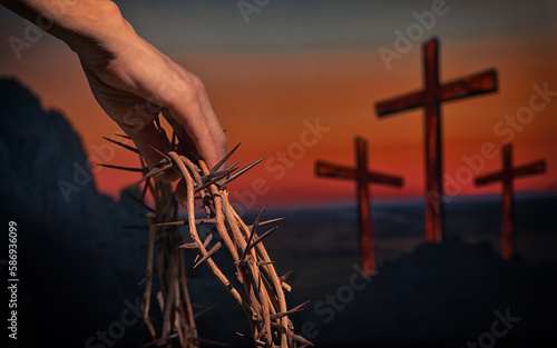 Hand holding crown of thorns andThree Crosses On Calvary Hill