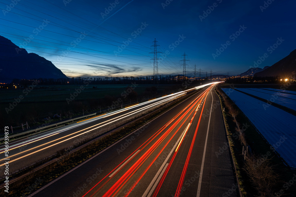 Vue des phares en filé sur l'autoroute le soir à 18h30 en direction du Valais en Suisse