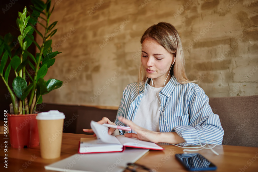 Smiling woman taking notes in notepad at table Smiling woman taking notes in notepad at table