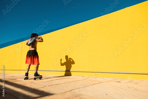 Black man on roller skates riding outside. Urban man posing with roller skates