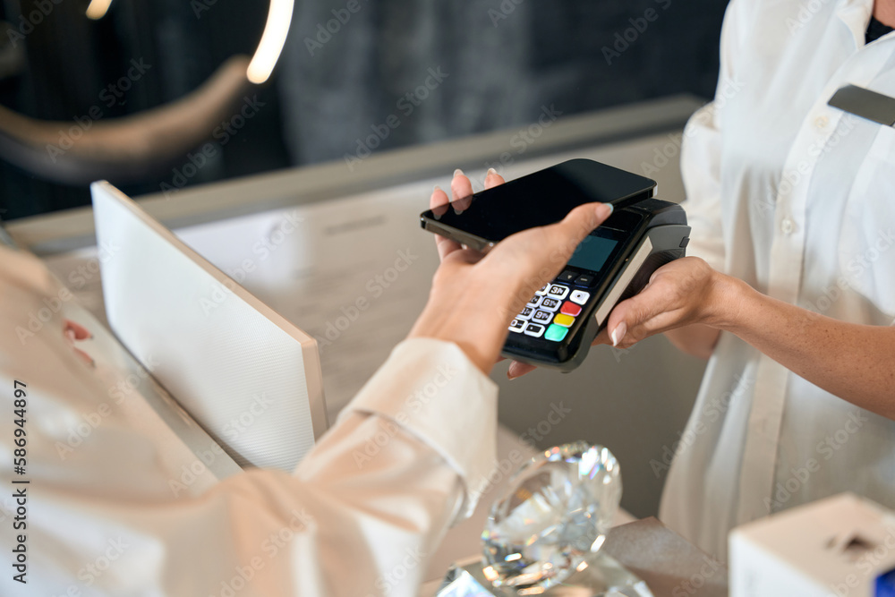 Lady finishing shopping by phone in beauty salon