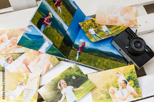 printed photos of family summer vacation lying on desk.