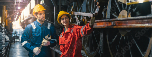 Female engineer and worker checking equipment in factory for repair
