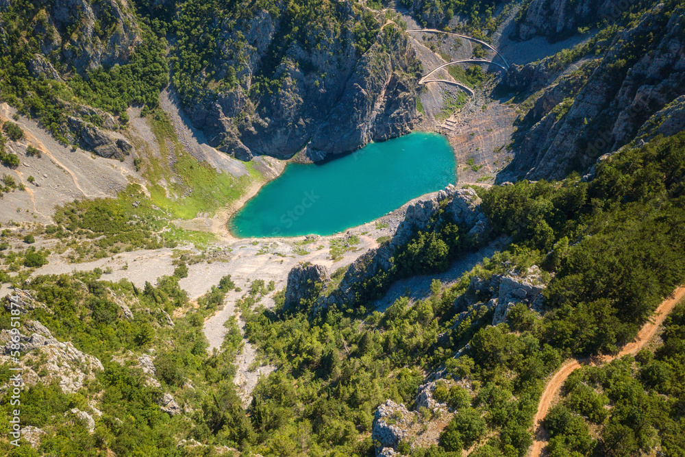 Scenic aerial view of Imotski Blue Lake (Modro jezero) in limestone crater, Dalmatia, Croatia. Nature summer landscape, popular tourist attraction, outdoor travel background