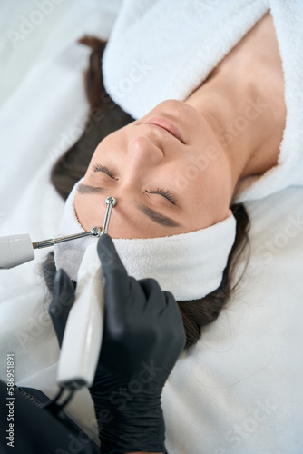 Nurse doing skin rejuvenation, working in salon photo