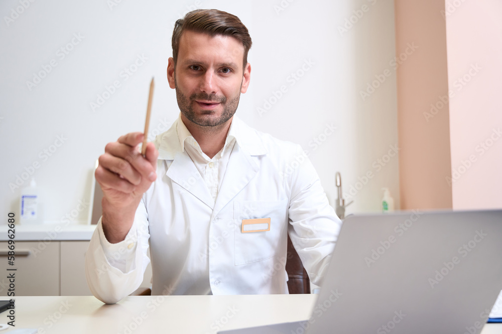 Fototapeta premium Handsome doctor in uniform is posing at the photo camera