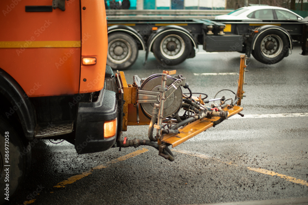 Washing equipment on road. Orange equipment on track.