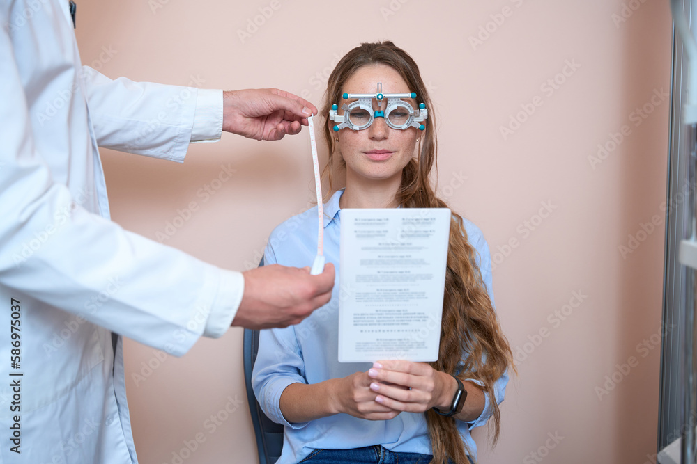 Pretty lady getting qualified checking her visual acuity in the medical office