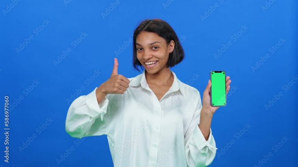 Shopping online, dark skinned woman in a white shirt finds good products and makes a successful purchase online using a smartphone, a stylish african woman on a blue background. Shopping online, dark skinned woman in a white shirt finds good products and makes a successful purchase online using a smartphone, a stylish african woman on a blue background.
