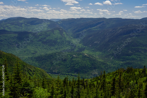 Panoramic view, landscape photography at Acropole des Draveurs, Quebec, Canada, with forest of pine trees, blue sky and clouds