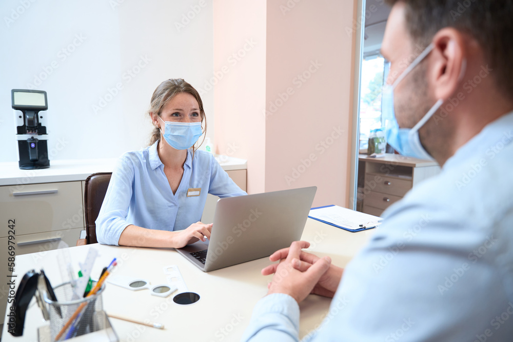 Attractive woman is consulting the man in the room indoors Attractive woman is consulting the man in the room indoors