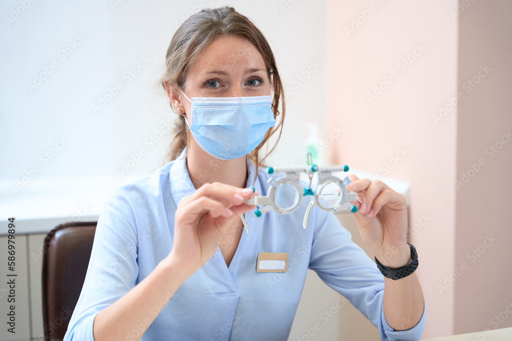 Elegant qualified doctor with trial frame is working in the clinic Elegant qualified doctor with trial frame is working in the clinic