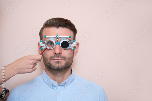 Adorable confident man is examining his eyesight in the modern optician center © Svitlana