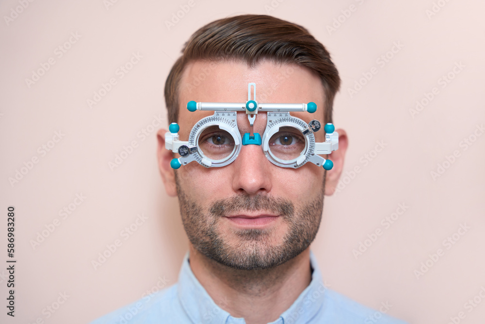 Confident male doing check up his visual acuity with special equipments