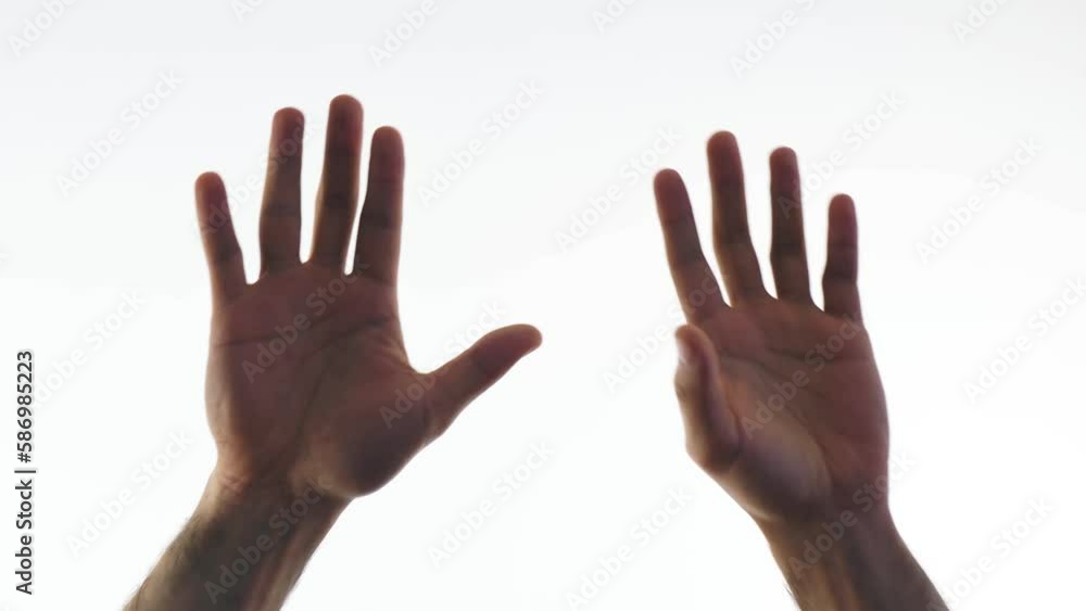The hands of a man palms forward on a white background, rise up and close together The hands of a man palms forward on a white background, rise up and close together