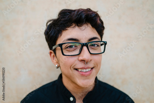 Close up view of a young transgender man looking at camera and smiling.