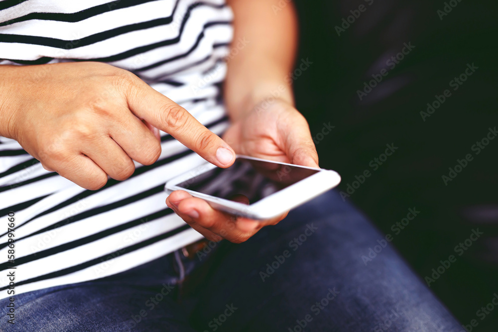 close up young man hand using on cell phone during rest on sofa living room. sitting in watching message on mobile smart phone during break relax. soft focus. close up young man hand using on cell phone during rest on sofa living room. sitting in watching message on mobile smart phone during break relax. soft focus.