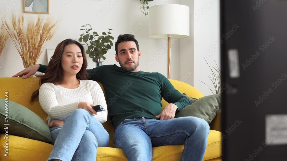 Happy couple hugging and watching TV in room Happy couple hugging and watching TV in room