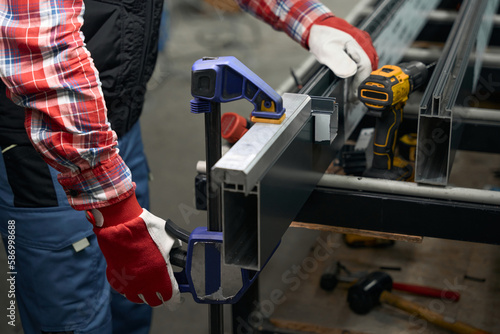 Man connecting two metal product together using tool