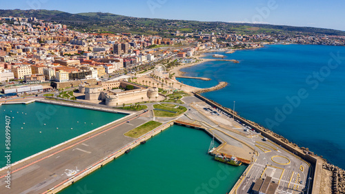 Aerial view of Fort Michelangelo, located in the port of Civitavecchia, in the Metropolitan City of Rome, Italy. On the city's waterfront is a park and a large white Ferris wheel.
