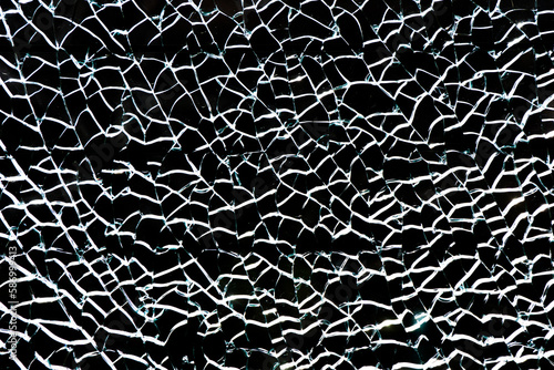 Shattered glass background. Distressed texture. White cracks isolated on black. Closeup glass break. Smashed glass surface. Crushed small pieces pattern.