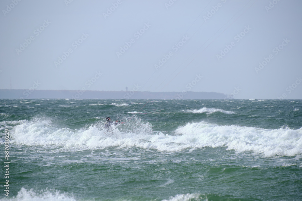 Kitesurfing in the sea during a storm and big waves.