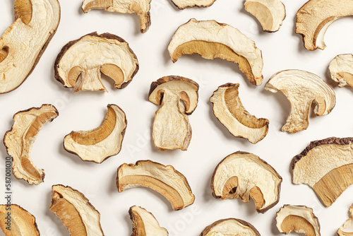 Dry slices of porcini as gourmet food ingredient, texture background from forest boletus mushrooms, top view, flat lay, beige pastel aesthetic monochrome pattern. Vegetable organic protein trend food
