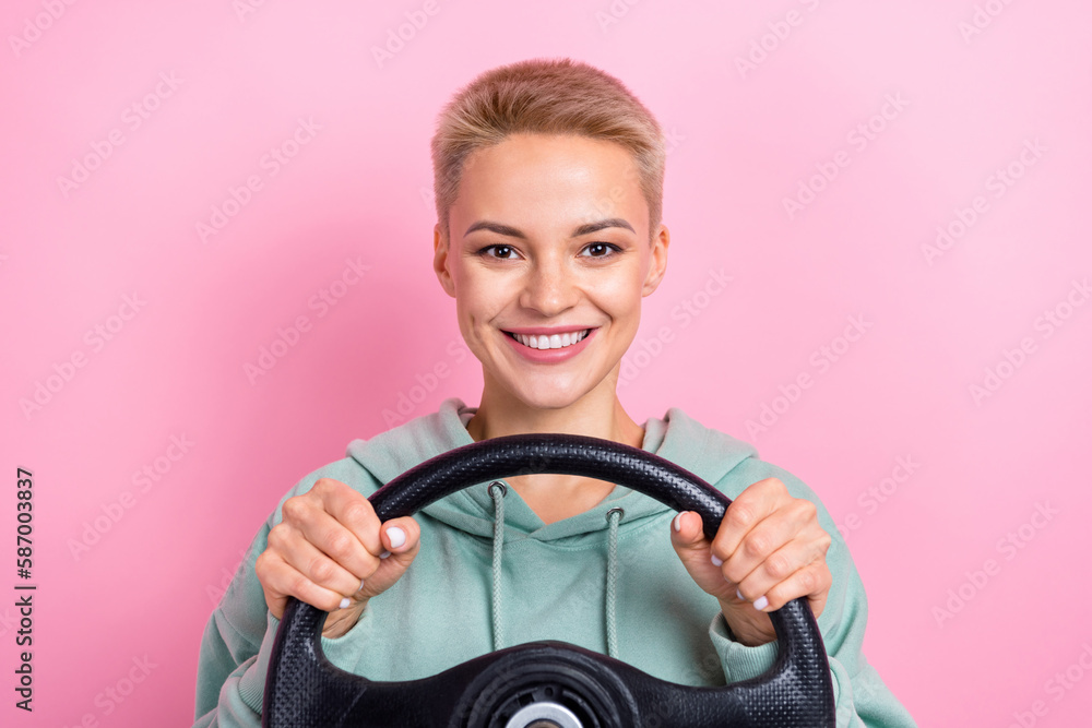 Photo portrait of lovely young lady holding steering wheel confident driver dressed stylish khaki clothes isolated on pink color background Photo portrait of lovely young lady holding steering wheel confident driver dressed stylish khaki clothes isolated on pink color background