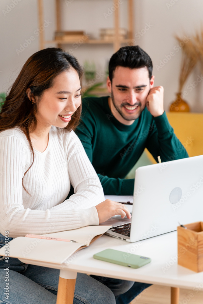 Obraz premium Happy couple working on laptop and making notes