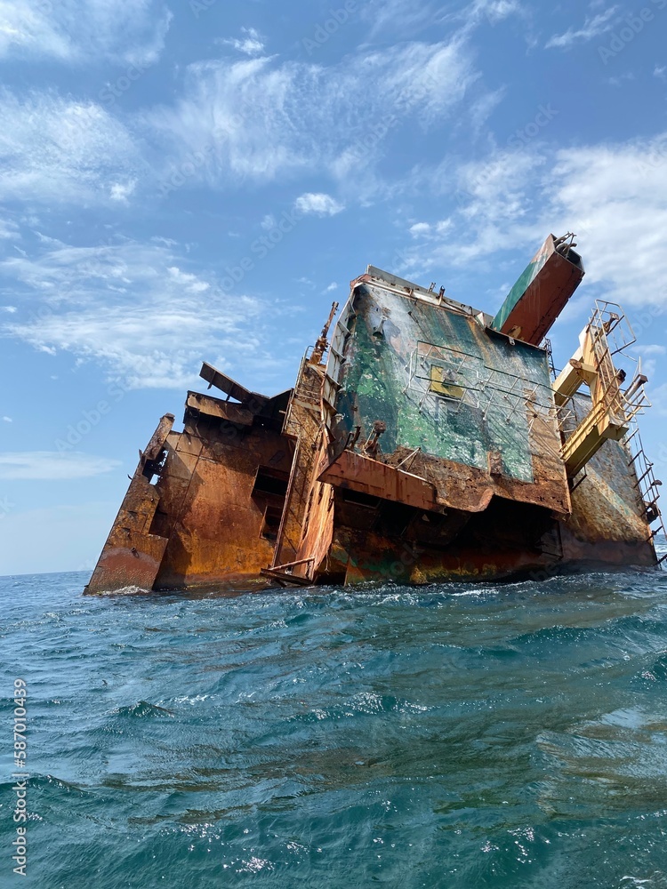 Rusty remains of a sunken ship submerged in water