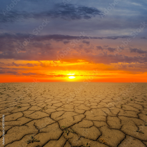 dry saline cracked earth at the dramatic sunset