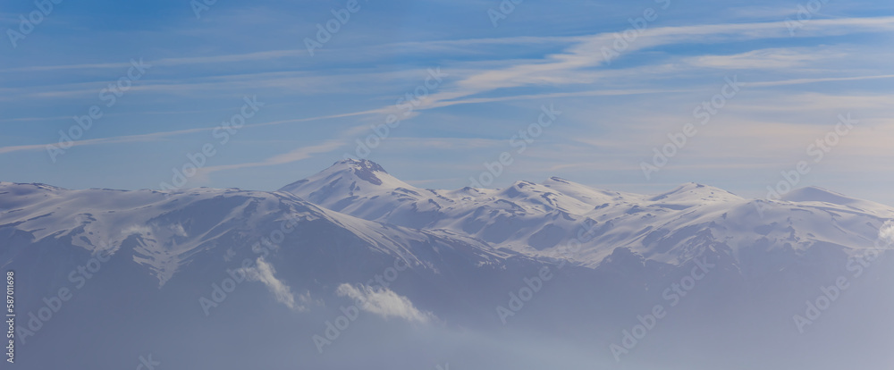 snowbound mountain ridge under dense cloudy sky