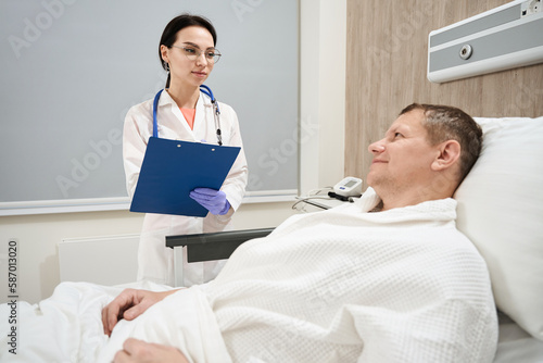 Elegant medicine specialist is talking with patient in ward