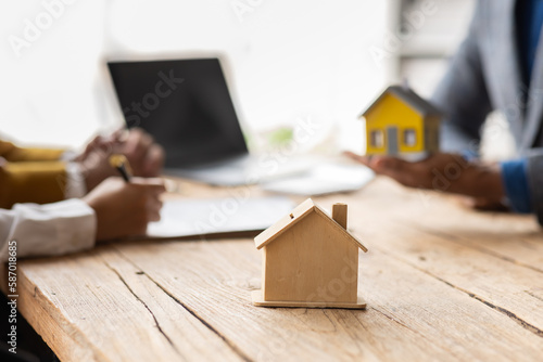 Family couple consultations with a lawyer or insurance House model with agent and customer discussing for contract to buy, get insurance or loan real estate or Mortgage property insurance.
