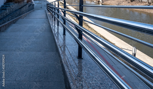 Stone sidewalk with metal railings.