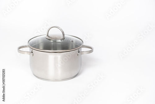 Stainless steel pot with glass lid and drain spout on a white background.