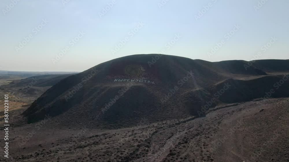 the flag of Kyrgyzstan is located on the mountain. drawing of a flag on the ground the flag of Kyrgyzstan is located on the mountain. drawing of a flag on the ground
