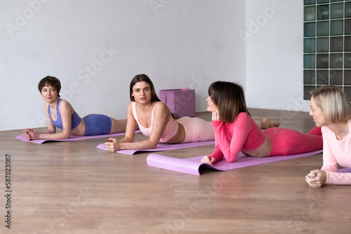 women training on fitness mat at sport class, exercises on floor