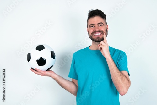 Funny Young man holding a ball over white background hold open palm new product great proposition