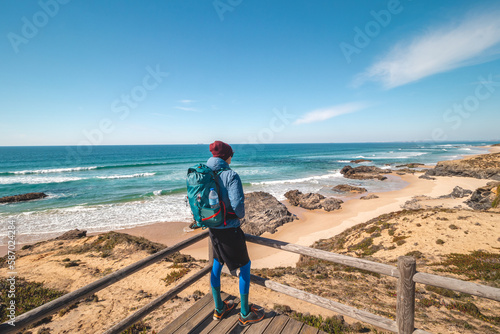Tourist enjoys the view from a viewpoint on a sandy beach on the Atlantic coast near Vila Nova de Milfontes, Odemira, Portugal. Following in the footsteps of the Rota Vicentina. Fishing Trail